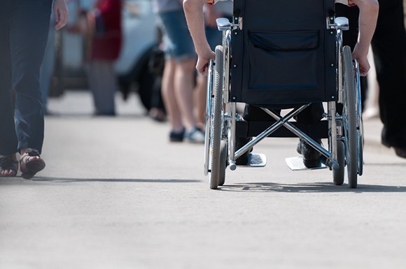 Man in a wheelchair on a busy street