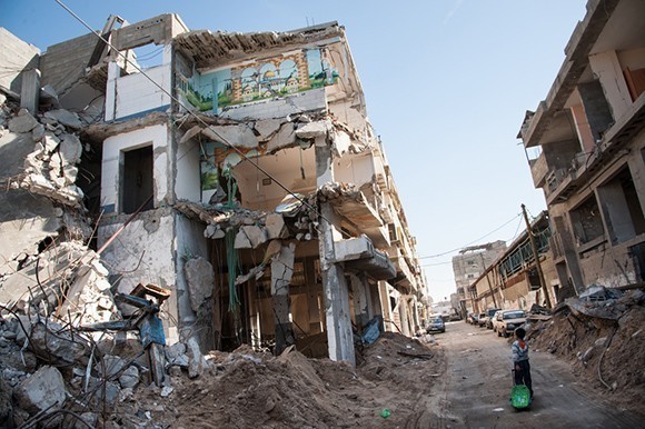 Child walks past bombed building in Gaza