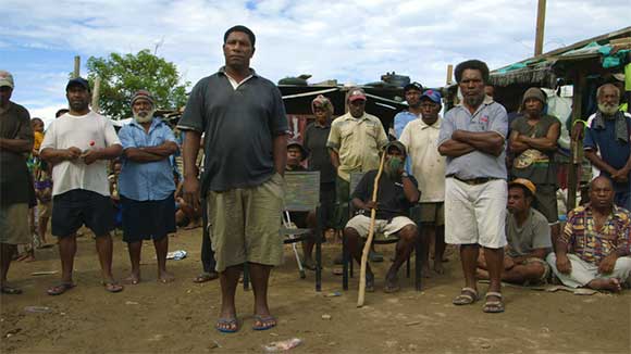 A still from The Opposition showing Joe Moses speaking to the community