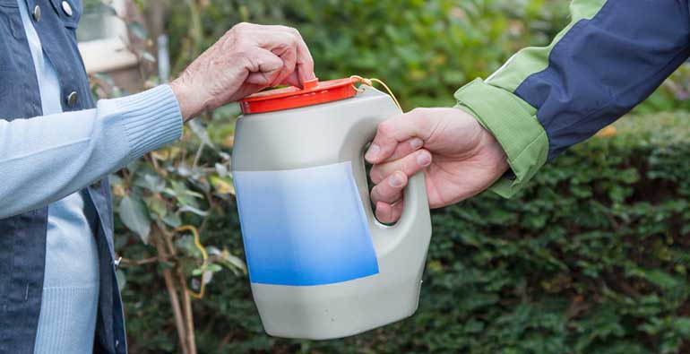 Man fundraising and woman putting money in collection tin