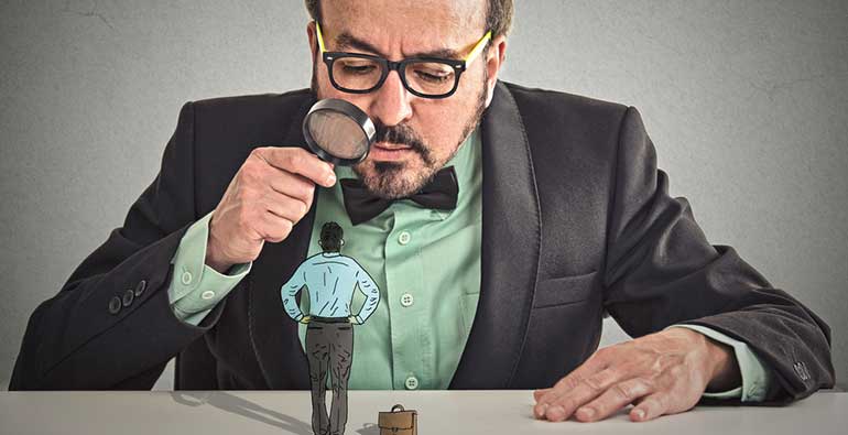 Man looking at candidate through magnifying glass