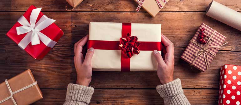 Man wrapping ethical gift for Christmas