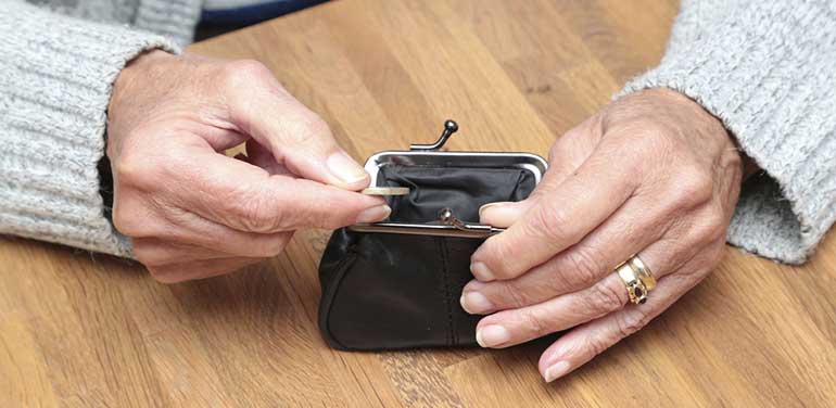 Age pensioner looking in her purse