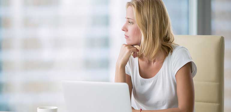 Woman at work looking out of window comtemplating