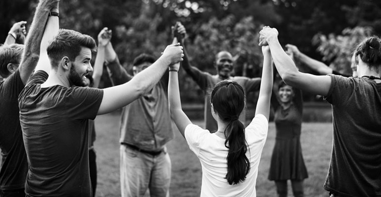 group holding hands with arms raised