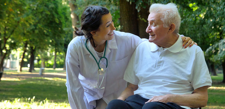 nurse with aged care patient outside