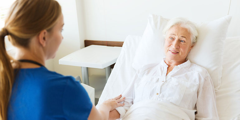 Nurse at the bedside of elderly lady