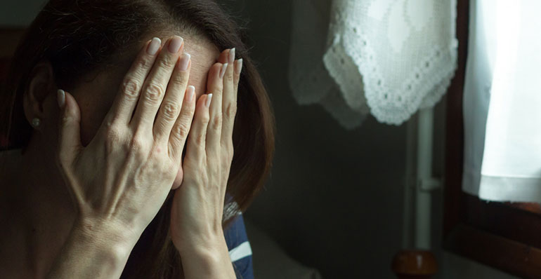 Woman covering her face with her hands