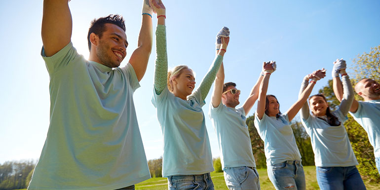 Group of volunteers with their hands in the air