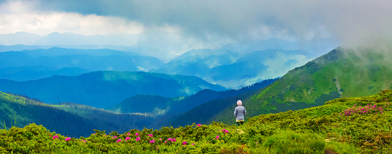 Woman standing on top of mountain enjoying view