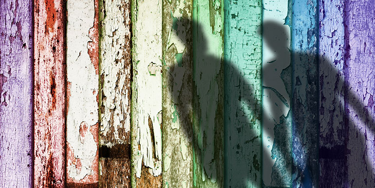 Rainbow fence with shadows holding hands