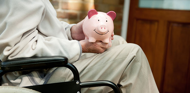 Man in a wheelchair with a piggy bank