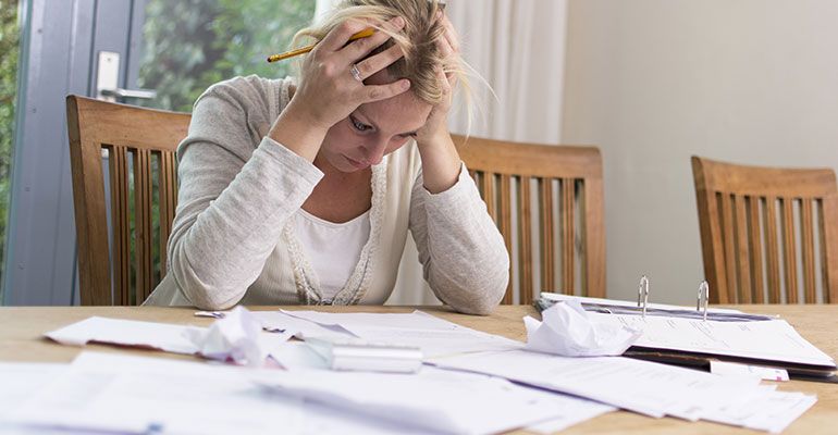 Woman at the table with lots of bills