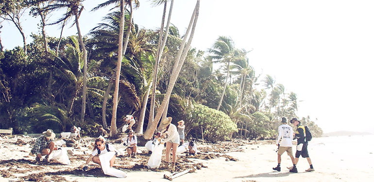 Group of people picking up litter on beach