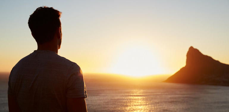 Man looking at over the sea towards an island