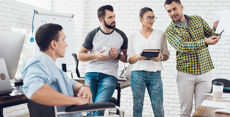 Team of designers sharing ideas with person in a wheelchair