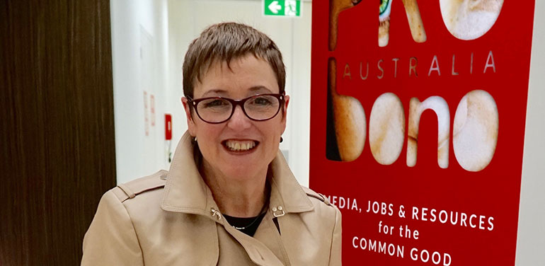 Lina Caneva standing next to Pro Bono sign at the Collins Street