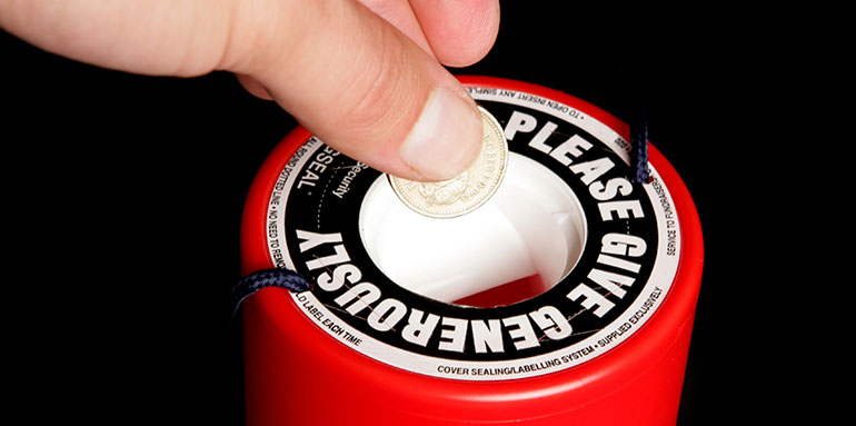 Someone putting a coin in a donation box