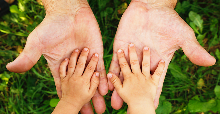 child's hands in adult's hands