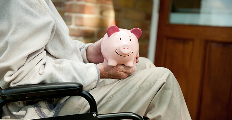 person with disability in wheelchair with piggybank