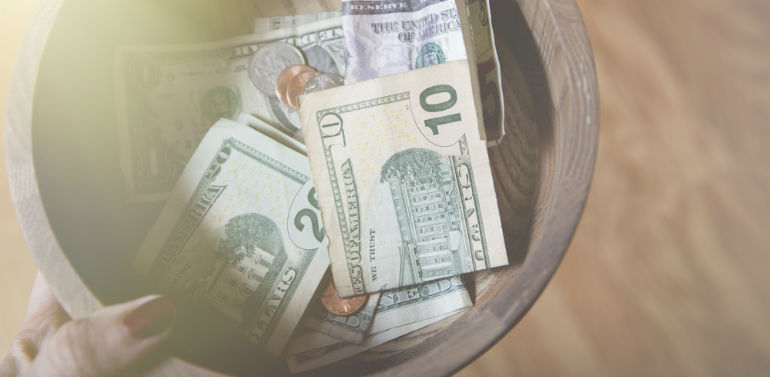 bank notes in a collection bowl