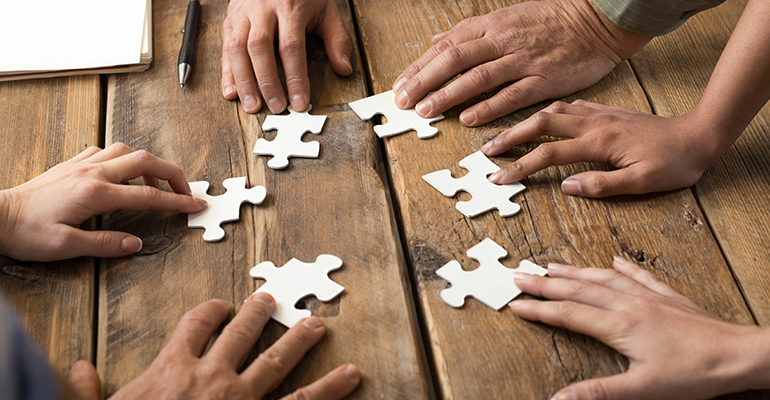 People around table with jigsaw puzzles