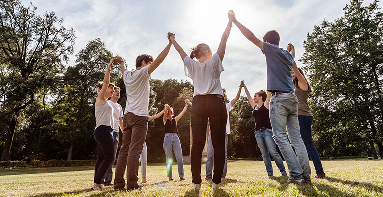 people in circle with hands together in the air