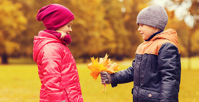 Boy giving girl leaves