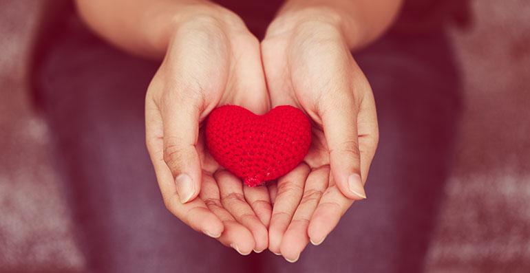 Woman holding out hands with heart in them