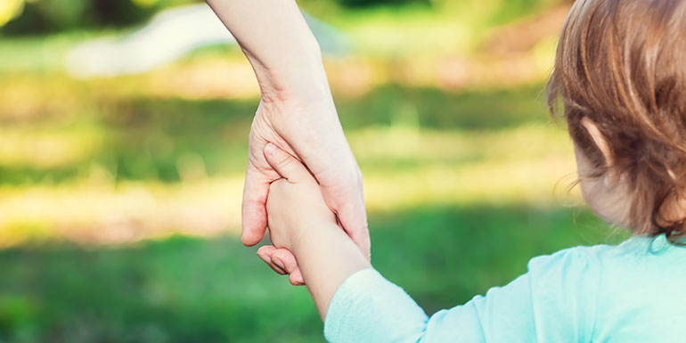 child holding hands with adult