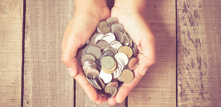 person with lots of coins in their cupped hands