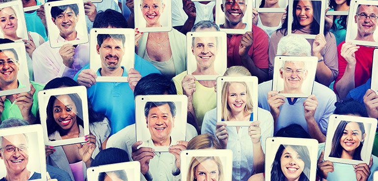 Lots of diverse people holding ipads with faces on the screen in place of their faces.