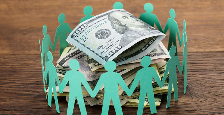 paper cut out of people surrounding money