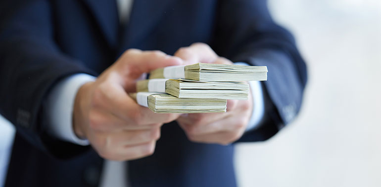 person in suit giving money