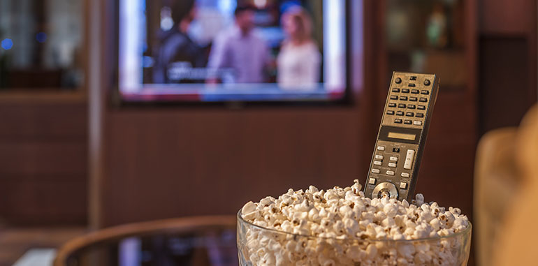 remote in popcorn in front of TV