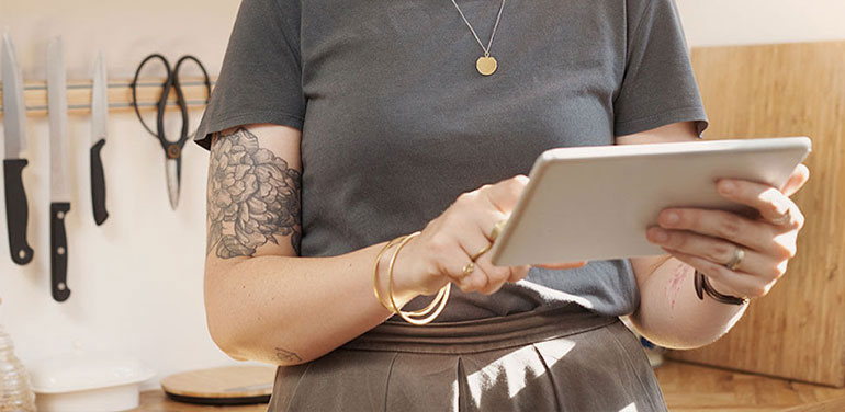 woman in a kitchen on an ipad