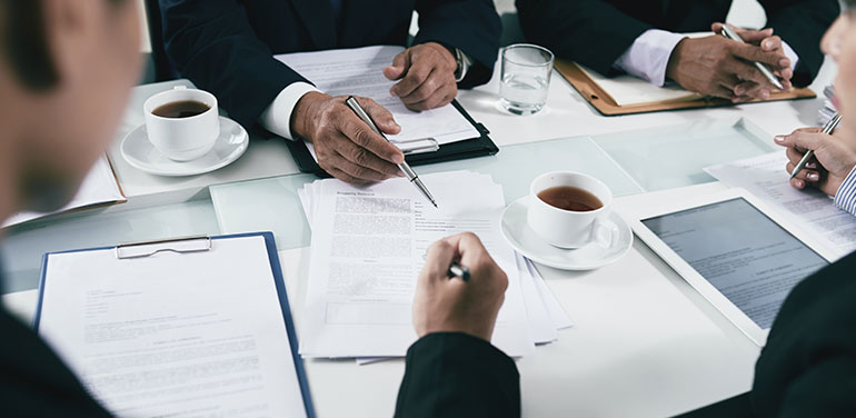 lawyers sitting round a table discussing paperwork