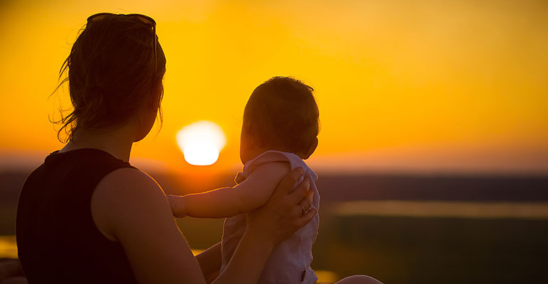 Women and son looking at a sunset