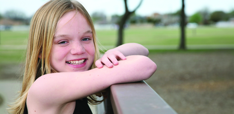 Girl leaning on a fence