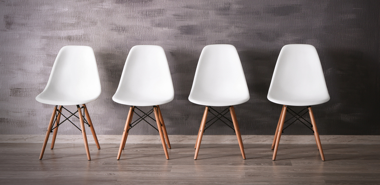 Four white chairs in office corridor