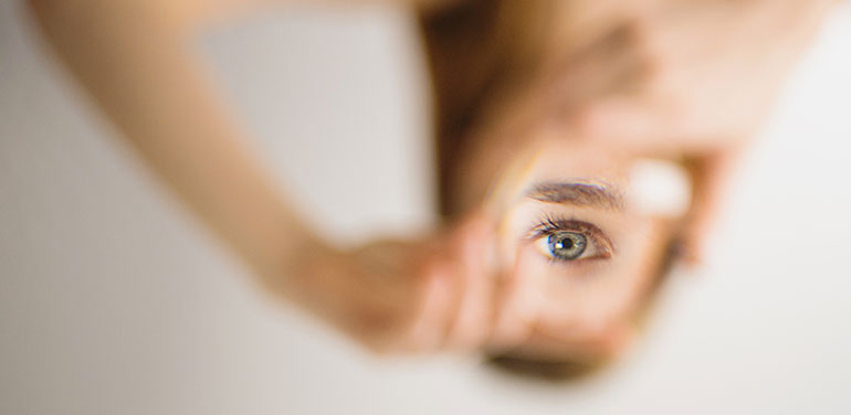 Blurry figure of woman with one eye in focus