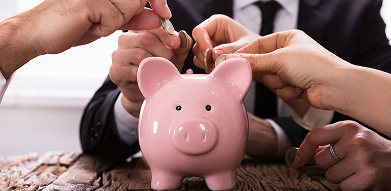 Group of people putting money in a piggy bank