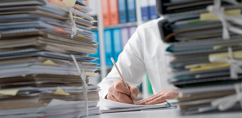 Man behind stacks of paperwork