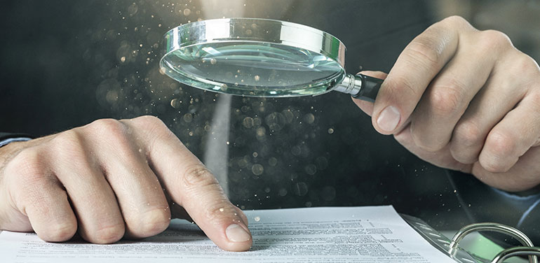 Person looking at data through magnifying glass