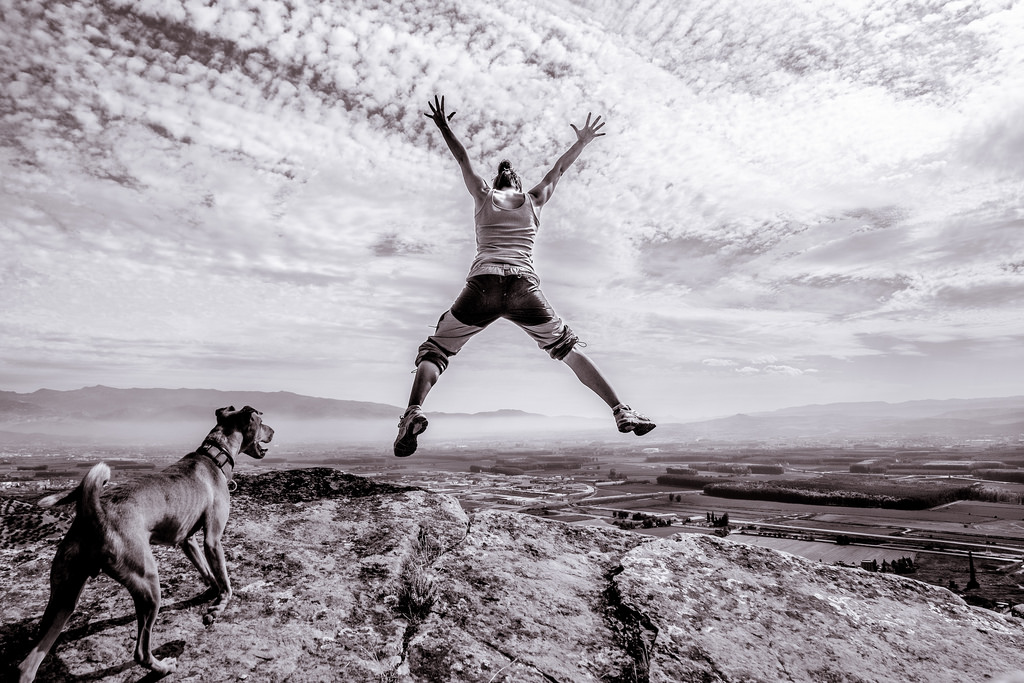 person jumping on the edge of a cliff