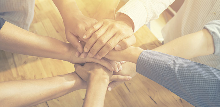 hands in the middle of circle of group of people