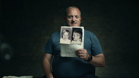 Jason King holding a photo from his childhood.