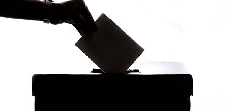 person putting a vote in box