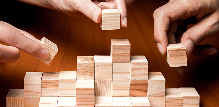 group of people building wooden blocks