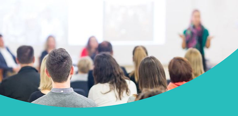 People attending a lecture seen from behind